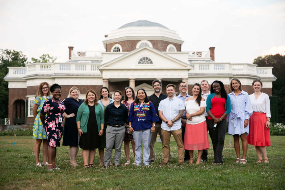 A group of smiling people standing on the lawn in front of Monticello.