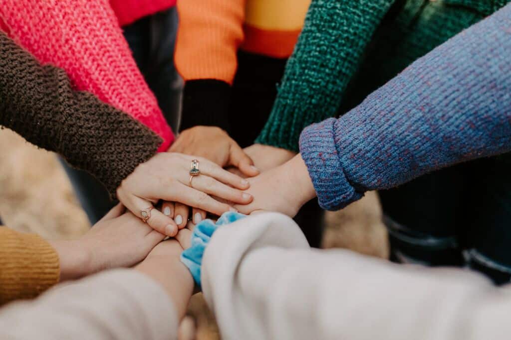 A group of people with hands in a circle.